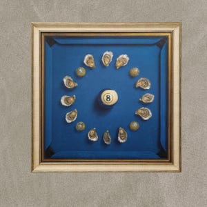 May include: A framed artwork depicting a blue pool table with an 8-ball at the centre. Oysters and decorative balls encircle the 8-ball. The frame is a light wood colour.