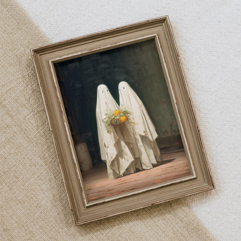 May include: Framed artwork featuring two figures draped in white sheets, resembling ghosts, holding a bouquet of oranges and greenery. The painting has a vintage aesthetic with a distressed wooden frame, perfect for Halloween decor.