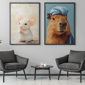 May include: Two framed art prints. One features a white mouse with pink ears and a pink tail. The other depicts a capybara wearing a blue turban. The prints are displayed above two gray armchairs.
