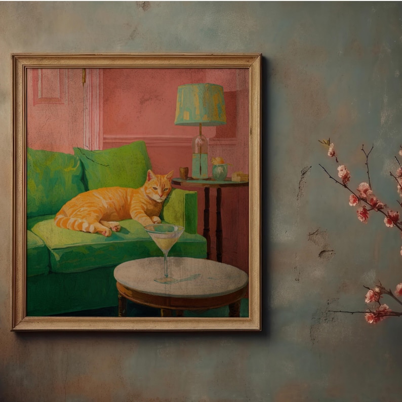 May include: A framed painting shows an orange tabby cat on a green sofa with green cushions. A martini glass is on a small table in front of the sofa. The room has a pink wall and a green lamp. A branch with pink flowers is on the right.