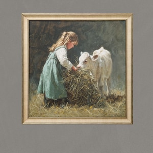Puede incluir: Pintura enmarcada que representa a una niña con un vestido turquesa alimentando con heno a un ternero blanco. La obra de arte, ambientada en un granero, tiene una paleta de colores neutros y un marco de madera clara. La pintura evoca la vida rural y la infancia.
