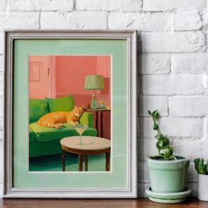 May include: Art print in a light green frame depicting an orange tabby cat on a green sofa. A cocktail sits on a small table. The room has a pink wall and a green lamp. The artwork is a stylish interior scene.