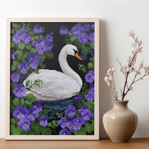 Op de afbeelding: Een ingelijst kunstwerk toont een witte zwaan met een oranje snavel, te midden van paarse bloemen en groene bladeren. Het kunstwerk staat op een houten oppervlak, naast een vaas met roze bloemen.