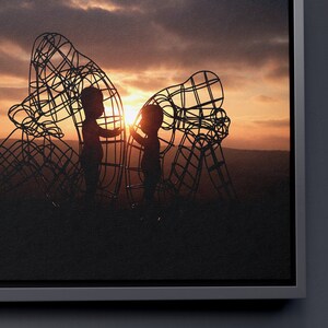 May include: Two children stand inside a large metal sculpture shaped like two figures, silhouetted against a sunset sky.