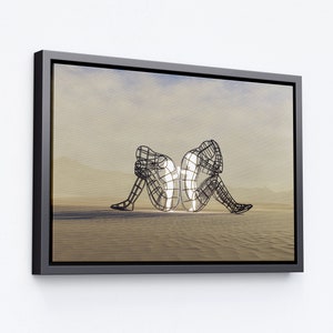 May include: A black and white framed canvas print of two wire sculptures of people sitting back to back in a desert landscape.