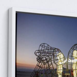Pu&ograve; includere: Una grande scultura in metallo di due figure che si abbracciano, sullo sfondo di un cielo crepuscolare. La scultura &egrave; realizzata in rete metallica, creando un effetto delicato ed etereo. Le figure sono illuminate dall'interno, proiettando un bagliore caldo.