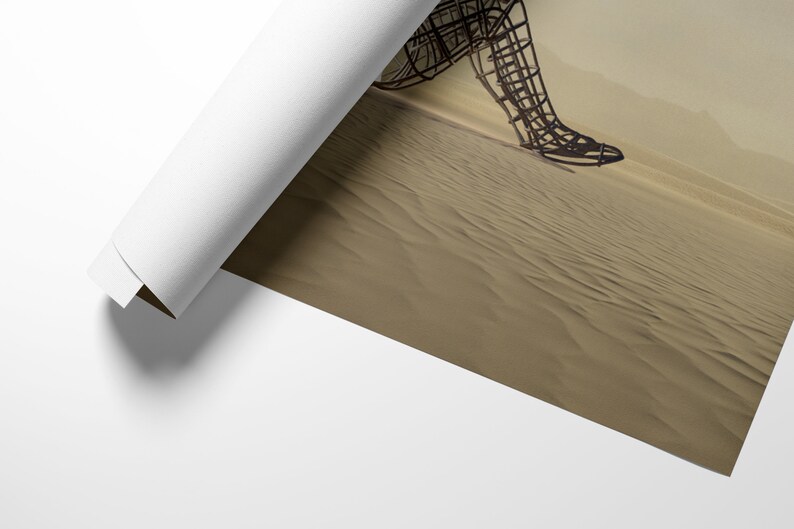 May include: A wire sculpture of a person walking across a sandy desert. The sculpture is made of metal and is in a rusted brown color. The desert is a light brown color and the sand is textured.