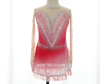 May include: A pink and red figure skating dress with a V-neckline, long sleeves, and a ruffled hem. The dress is decorated with rhinestones and has a sheer overlay. The dress is on a mannequin and the text "WEARTHISCOSTUME @ETSY" is at the bottom of the image.