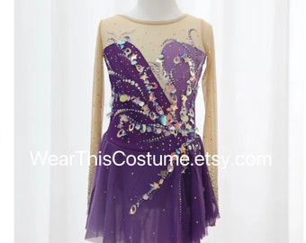 Può includere: Abito da pattinaggio artistico viola con maniche lunghe e un sovrapporsi trasparente. Il corpetto è decorato con paillettes e perline iridescenti in un motivo floreale. La gonna è un unico strato di tulle viola.