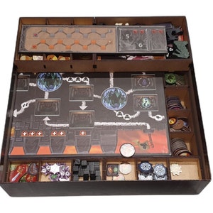 May include: A wooden game organizer with compartments for storing game pieces. The organizer has a black exterior and a brown interior. The organizer is filled with various game pieces, including dice, tokens, and cards. The organizer is designed to fit a specific board game.
