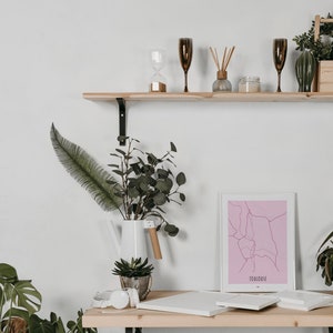 Może przedstawiać: Drewniana p&oacute;łka na tle białej ściany, ozdobiona roślinami, wydrukiem mapy i r&oacute;żnymi elementami dekoracyjnymi. P&oacute;łka jest zamontowana na białej ścianie.