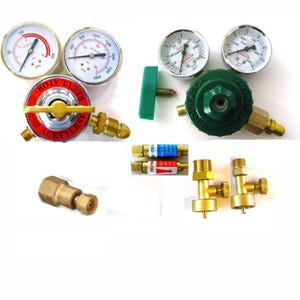 May include: A collection of gas welding equipment including two pressure regulators with gauges, one labeled Acetylene and one green Yamato regulator. Also included are two small cylindrical check valves with blue and red labels, two brass fittings, and one brass adapter.