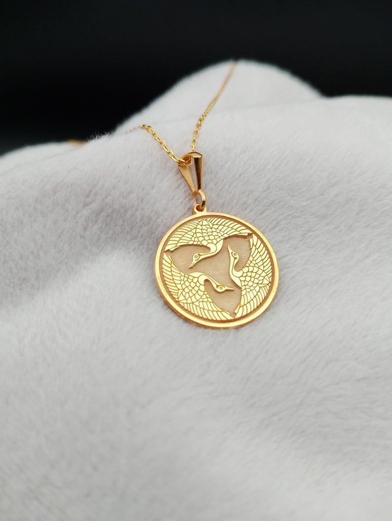 a gold necklace with a horse on it