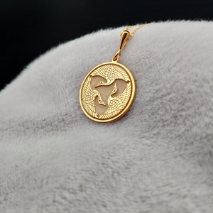 a close up of a gold pendant on a person's head