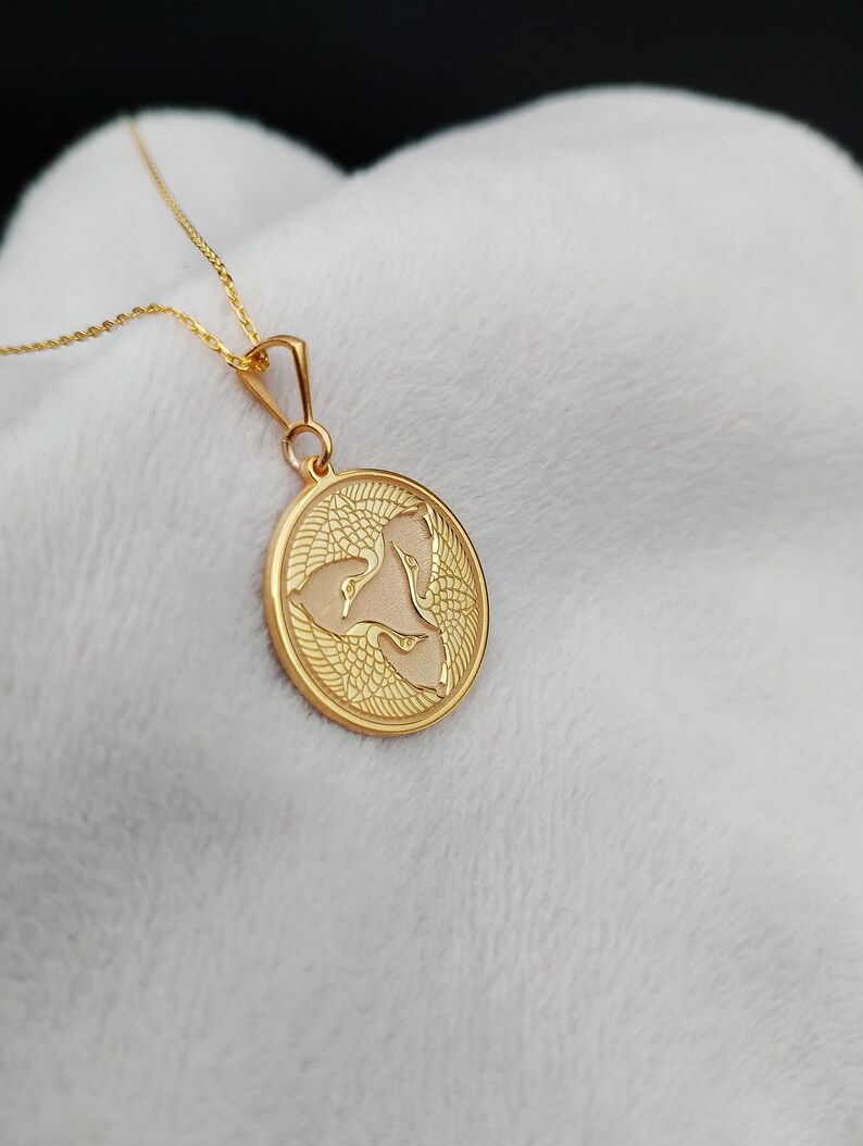 a gold necklace with a woman's face on it
