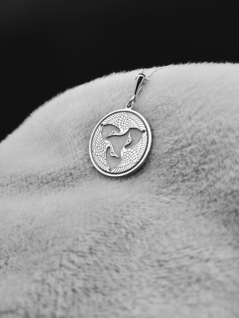 a close up of a person's hand with a pendant on it