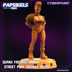 May include: A tan-colored figurine of a female character with a mohawk hairstyle, wearing a crop top, underwear, and boots. The figure has spiky shoulder pads and bracelets. Text on the base reads "SUPAH FRIENDS GANG STREET PUNK ROSANA ROZES."