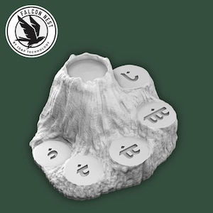 May include: A white, textured, tree stump-shaped object with five circular platforms, each bearing a unique symbol. The top of the stump has a circular indentation. The Falcon Nest logo is in the upper left corner.
