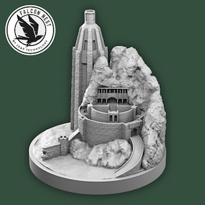 Può includere: Modello grigio stampato in 3D di una fortezza con un'alta torre, montagne rocciose e una strada tortuosa. Il modello poggia su una base circolare. Il logo Falcon Nest si trova nell'angolo in alto a sinistra.