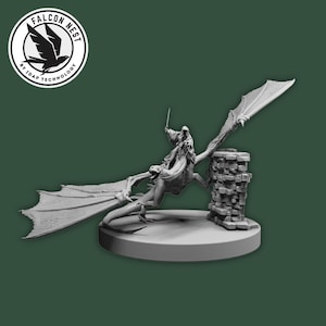 Pode incluir: Estatueta em tons de cinza de um dragão com um cavaleiro, empoleirado em uma estrutura de pedra. O dragão tem grandes asas abertas e está montado em uma base circular. O logotipo Falcon Nest está no canto superior esquerdo.