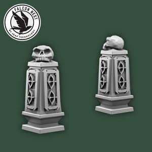 Könnte beinhalten: Zwei graue, dekorative Säulen mit Totenkopfaufsätzen. Jede Säule hat einen rechteckigen Körper mit geometrischen Aussparungen und einen quadratischen Sockel. Das Falcon Nest-Logo befindet sich oben links.