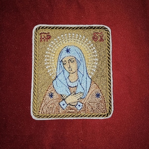 May include: Embroidered patch featuring a religious icon of the Virgin Mary with a gold frame and a blue and white halo. The patch has the letters "MP, OY" in the top corners.