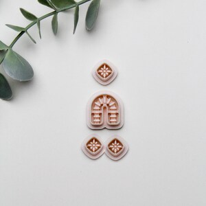 Peut inclure: Un ensemble de quatre emporte-pièces en plastique rose. Les emporte-pièces sont en forme de diamant avec un motif d'étoile, d'une arche avec un motif décoratif et de deux autres diamants avec un motif d'étoile.