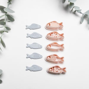 Peut inclure: Un ensemble de trois tasses en céramique avec une finition mate et mouchetée. Les tasses sont dans les tons crème, gris clair et gris foncé. Chaque tasse a un design simple et minimaliste et une anse arrondie.