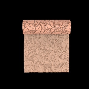 Peut inclure: Un rouleau à pâtisserie cylindrique de couleur pêche avec un motif en relief répétitif représentant des chats squelettes, des chauves-souris et des feuilles stylisées. La surface présente des détails gravés pour imprimer les motifs.