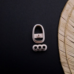 May include: A set of two pink plastic cookie cutters. One cutter is shaped like a boat with a small hole in the centre. The other cutter is shaped like three circles connected together.