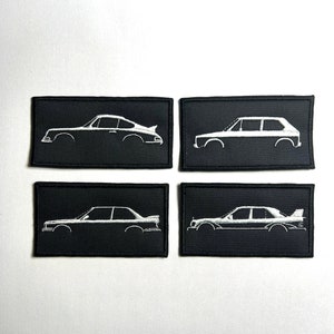 Könnte beinhalten: Vier schwarze gestickte Patches mit weißen Umrissen verschiedener Automodelle. Die Patches befinden sich auf einem weißen Hintergrund.