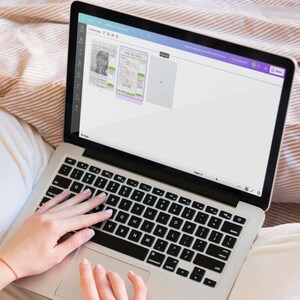 May include: A person using a laptop computer with a white background and a purple toolbar. The laptop screen shows a document with a newspaper clipping.