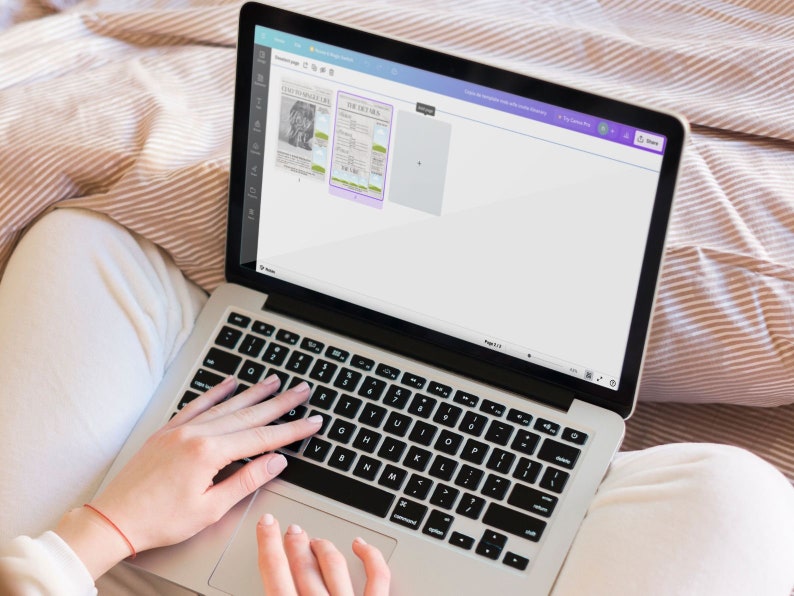May include: A person using a laptop computer with a white background and a purple toolbar. The laptop screen shows a document with a newspaper clipping.