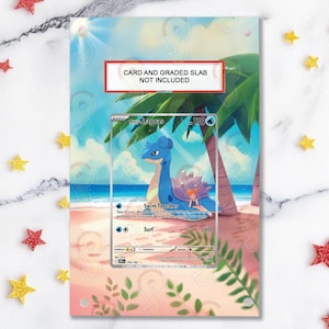 May include: A card holder featuring a beach scene with palm trees and a blue sky. The holder is designed to display a Pokémon card, with the text "CARD AND GRADED SLAB NOT INCLUDED" at the top. The card features a blue Lapras.