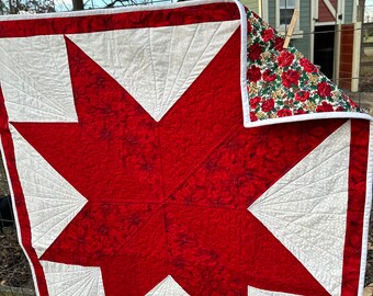 100% cotton Eight pointed star Christmas poinsettia quilt .  This little quilt makes a powerful statement with its bold red & white theme.