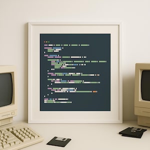 Könnte beinhalten: Ein gerahmter Druck mit einer stilisierten Darstellung von Computercode in verschiedenen Farben, darunter Grün, Rosa und Blau, vor einem dunklen Hintergrund. Der Druck befindet sich in einem weißen Rahmen, und ein Vintage-Computer und eine Tastatur sind im Hintergrund zu sehen.