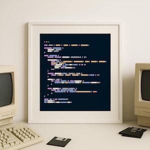 Könnte beinhalten: Ein gerahmter Druck mit farbenfrohen Zeilen von Computercode auf dunklem blauem Hintergrund. Das Kunstwerk wird auf einer weißen Oberfläche präsentiert, zusammen mit einem Vintage-Computer, einer Tastatur und einer Diskette. Die Ästhetik verbindet Technologie und Kunst.
