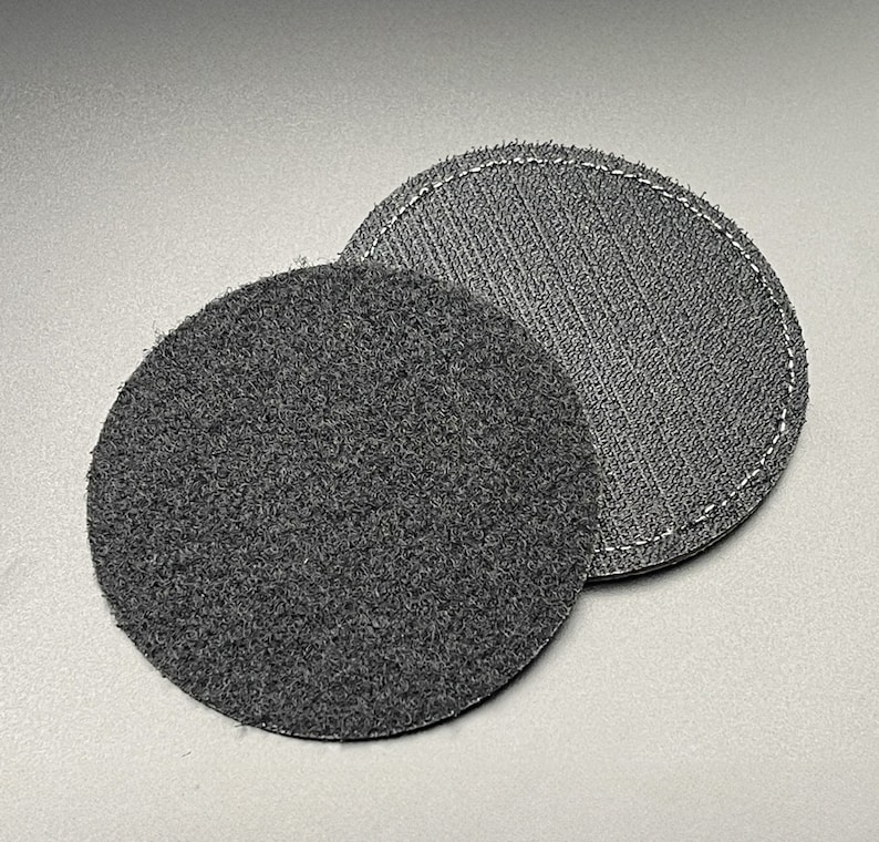 May include: Two black round velcro patches, one with a fuzzy surface and the other with a smooth surface.