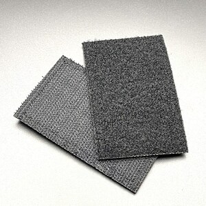 May include: Two pieces of black hook and loop fastener, also known as Velcro. The larger piece is on top of the smaller piece.