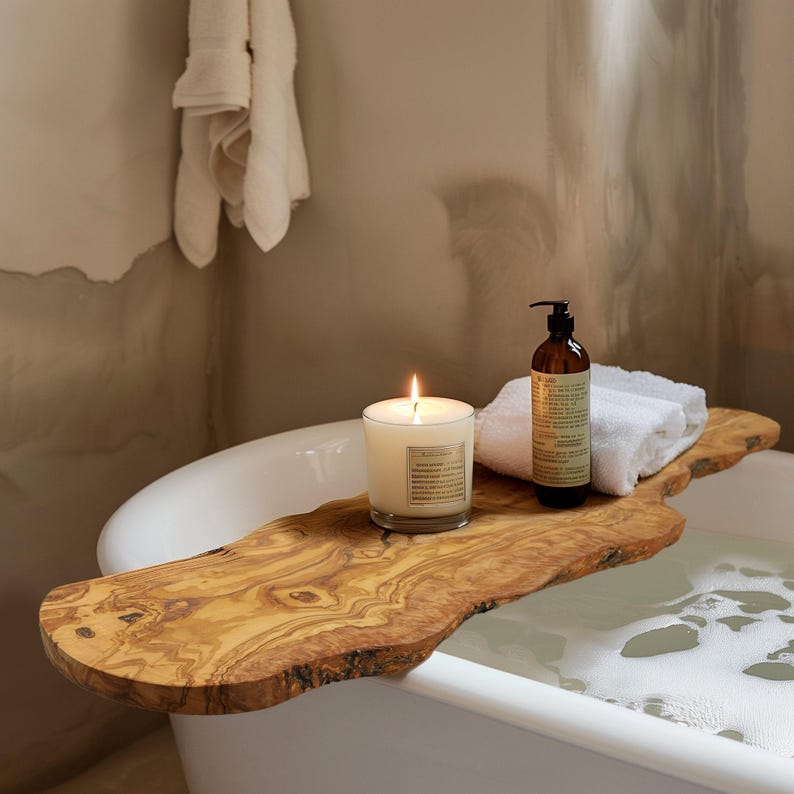 Experience ultimate relaxation with this handcrafted olive wood bath board, showcasing a rich grain pattern. It’s the perfect addition to any bath, providing space for your relaxation essentials.