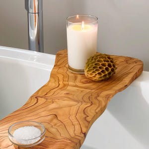 Crafted from durable olive wood, this bathtub caddy features a beautifully contoured design that fits snugly over your bathtub, offering a stable surface for your relaxation essentials during a luxurious soak