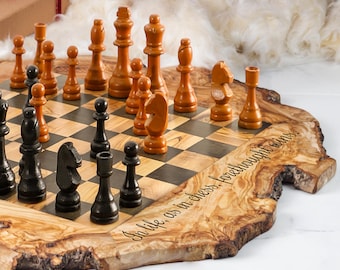 Puede incluir: Un juego de ajedrez de madera con piezas negras y marrones sobre un tablero a cuadros. El tablero está sobre una base de madera de borde vivo con la inscripción "In life, as in chess, forethought wins."
