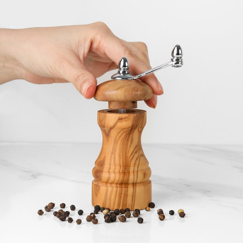 Premium Wooden Spice Mill made from olive wood, ideal for grinding peppercorns or salt, with an adjustable coarseness screw and smooth operation.