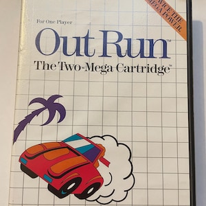 May include: A Sega Genesis game cartridge for the game Out Run. The cartridge is white with a blue and red car graphic and the text "Out Run" in blue. The text "The Two-Mega Cartridge" is also in blue. The text "Twice the Mega Power" is in orange.