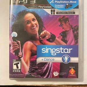 May include: A PlayStation 3 game case for SingStar Dance. The case features a pink and purple background with two people singing into microphones. The game is compatible with PlayStation Move.