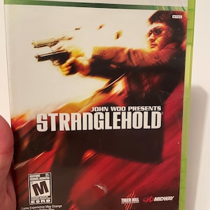 Pode incluir: Caixa de jogo Xbox 360 para Stranglehold, um jogo de ação de John Woo. A capa apresenta um homem segurando uma arma, com o título do jogo e a classificação PEGI visível.