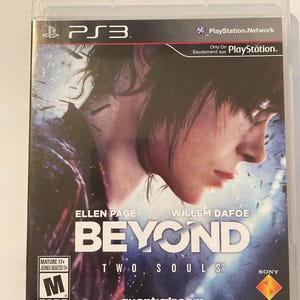 Könnte beinhalten: Ein PlayStation 3 Videospiel-Etui mit blauem und weißem Hintergrund. Das Spiel heißt "Beyond: Two Souls" und zeigt Ellen Page und Willem Dafoe. Das Spiel ist von der ESRB mit M für Mature bewertet.