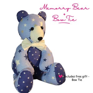 May include: A blue teddy bear with a star pattern, wearing a cream-colored bow tie. The bear has black button eyes and a stitched black nose. The text "Memory Bear + Bow Tie" is written above the bear.