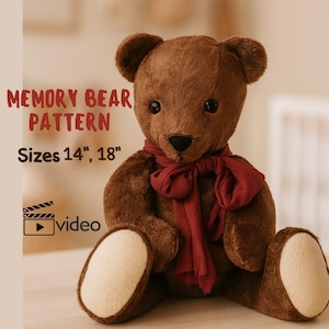 Peut inclure: Un ours en peluche marron avec une écharpe bordeaux. L'ours a un museau et des coussinets de pieds de couleur claire. Le texte sur l'image indique "MEMORY BEAR PATTERN" et "Tailles 35.5cm, 45.7cm". Une icône vidéo est également présente.