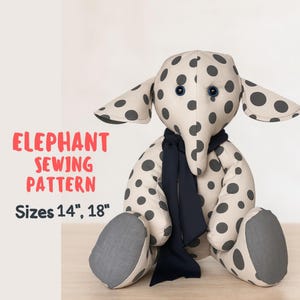 Pode incluir: Um elefante de pelúcia com um corpo creme e grandes bolinhas cinzentas. Possui orelhas grandes, olhos azuis de botão e um cachecol azul escuro. O texto "ELEPHANT SEWING PATTERN" e "Sizes 14", 18"" é exibido em vermelho e preto.